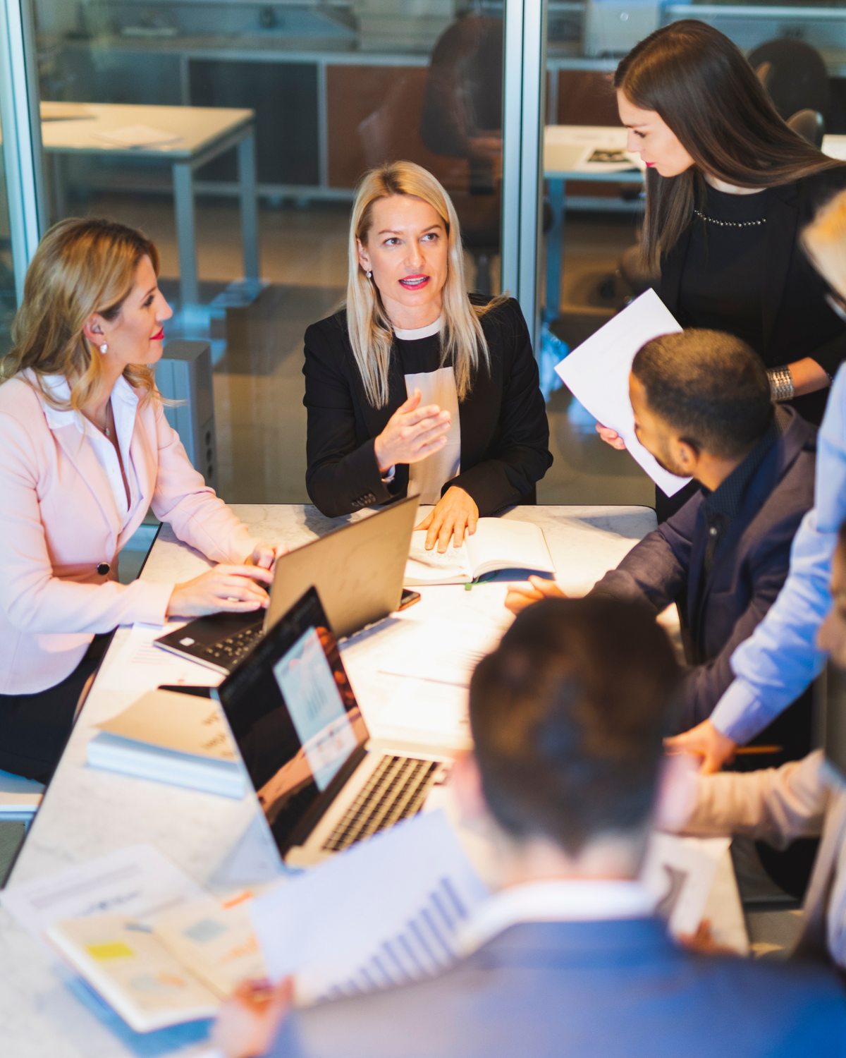 A group of workers around a laptop having a meeting